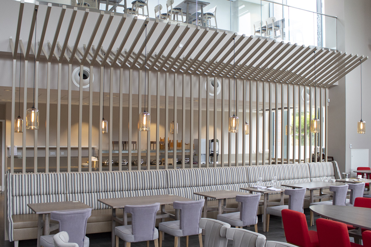 Bespoke metalwork room divider with banquette seating in the foreground